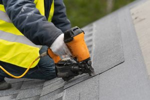Qualified,Roofer,Worker,In,Protective,Uniform,Using,Air,Or,Pneumatic